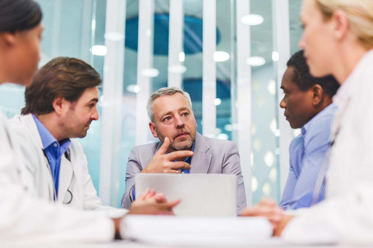 Group of physicians gathered around a computer.